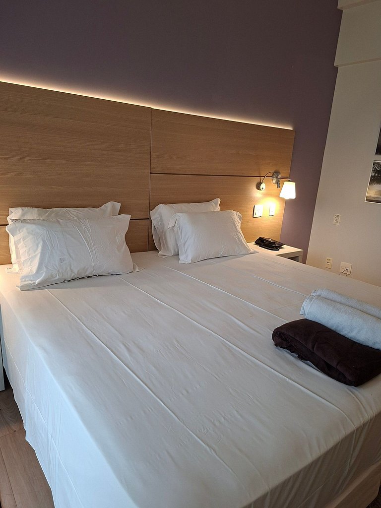 Flat com varanda, cama king e vista mar