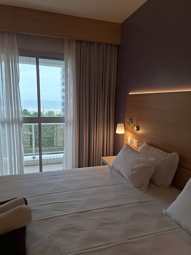 Flat com varanda, cama king e vista mar